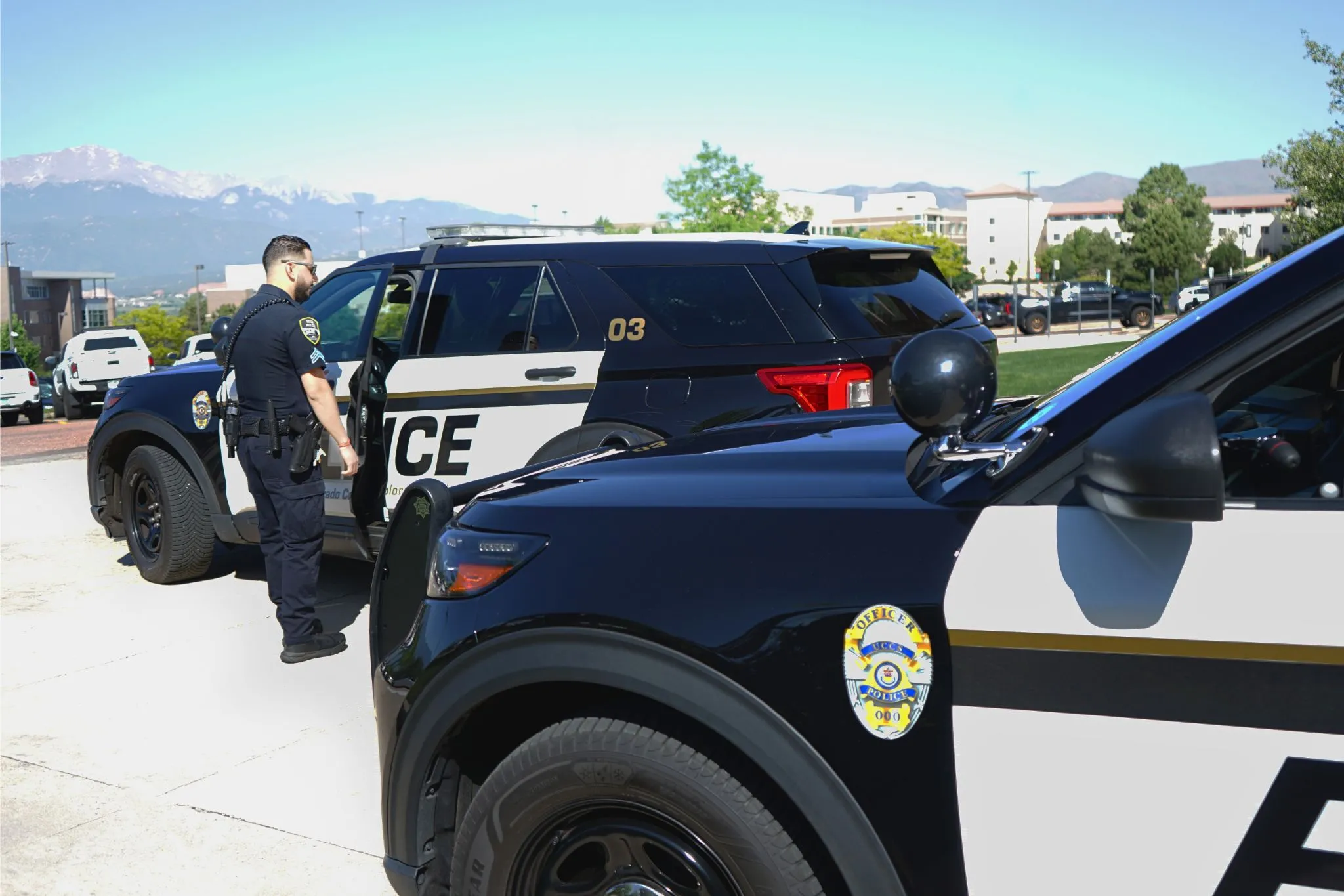 Campus police officer standing next to police vehicle