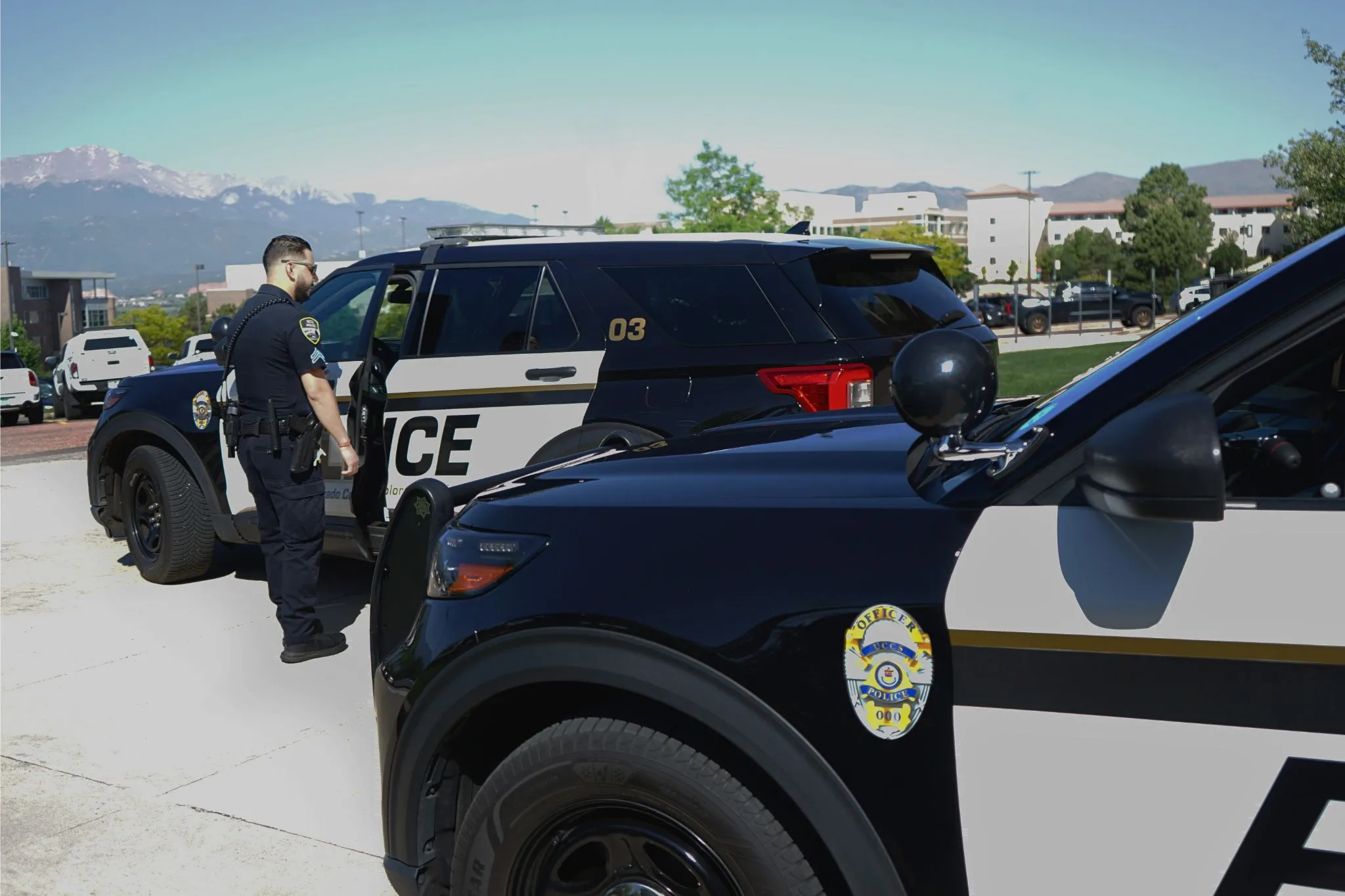 Campus police officer standing next to police vehicle